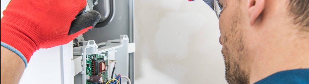 man wearing red work glove installing furnace